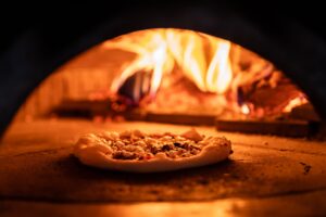 Woodfire-pizza-oven-with- burning-flames-cooking-pizza